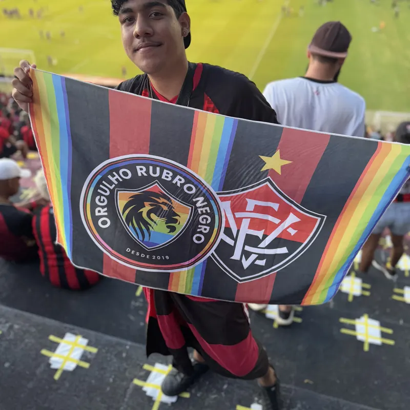 Torcedor jovem abrindo a bandeira da ORN na arquibancada do Barradão