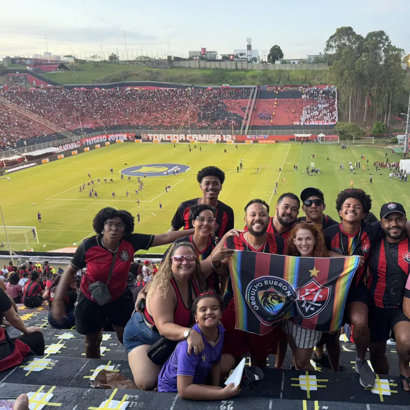Grupo da ORN na arquibancada com a bandeira da torcida e o gramado do Barradão ao fundo